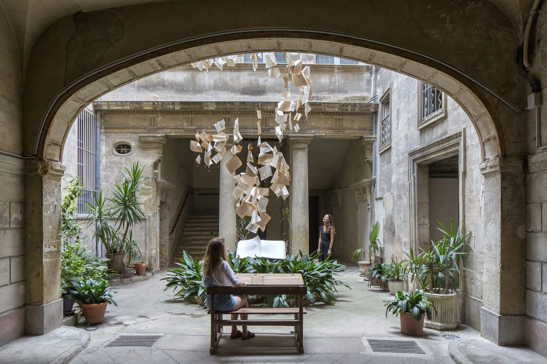 Cour intérieure vue sous l'arche, le pupitre au centre sous les pages suspendues