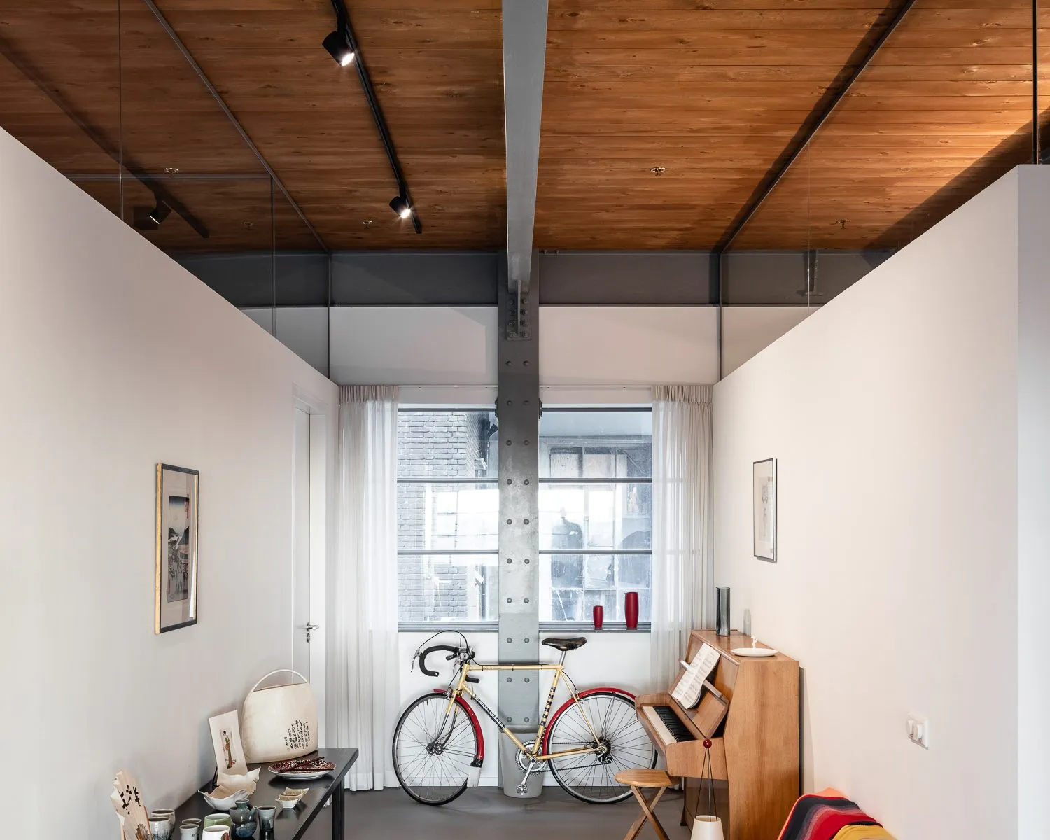 Chambre-bureau, vélo de course posé contre le mur sous le plafond en bois