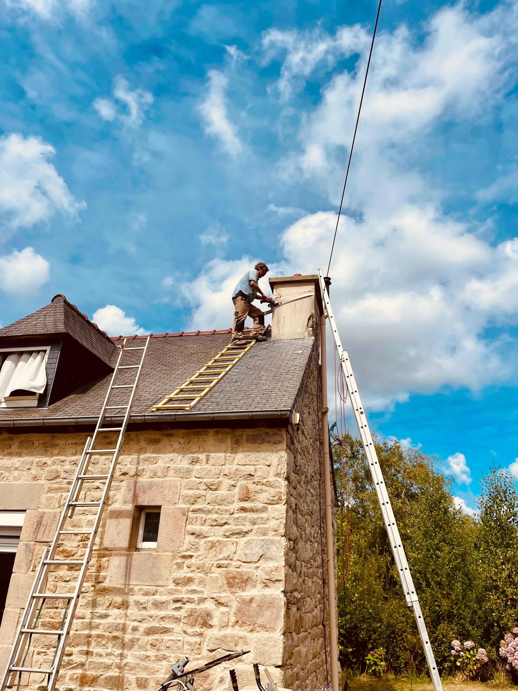 Couvreur sur l'échelle pendant la réfection de la toiture